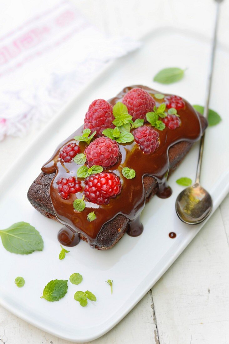 Chocolate cake topped with a fresh raspberries and mint