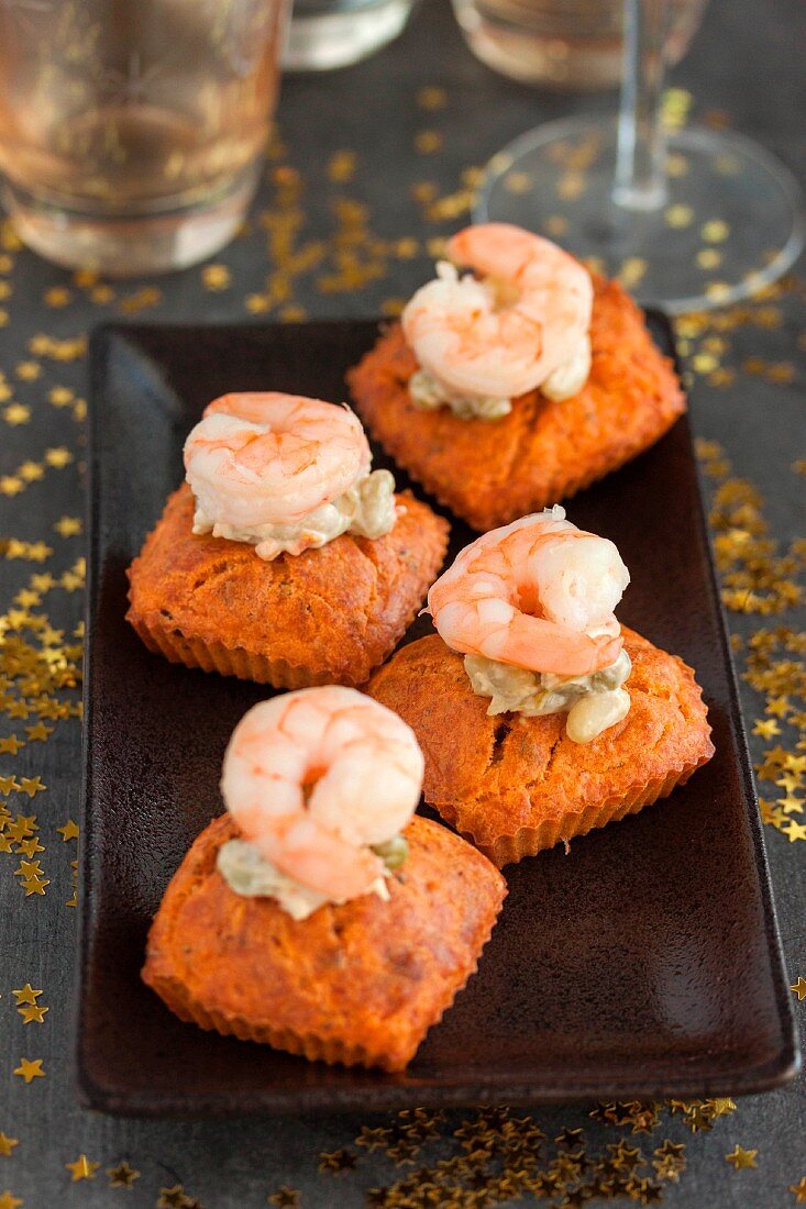 Small carrot cakes topped with shrimps, mayonnaise with capers