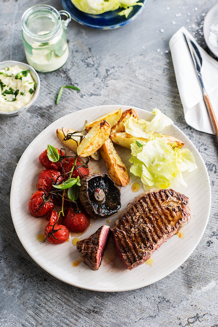 Grilled steak, potatoes, grape tomatoes and roasted mushrooms