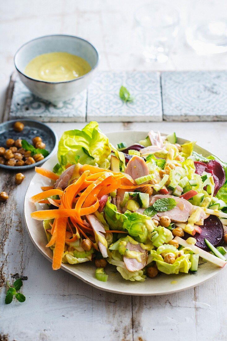 Salat mit Kichererbsen, Karotten, Rote Bete, Sellerie, Apfel, geräucherter Hähnchenbrust und Currysauce