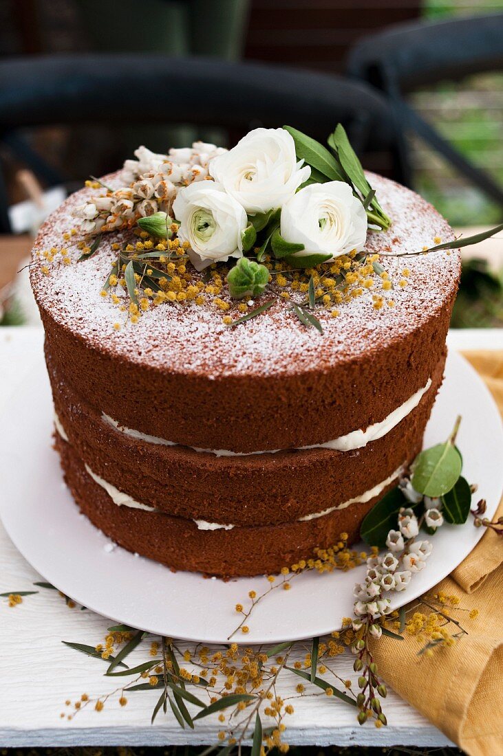 Naked Cake mit Kakao, Himbeeren und Blumendeko