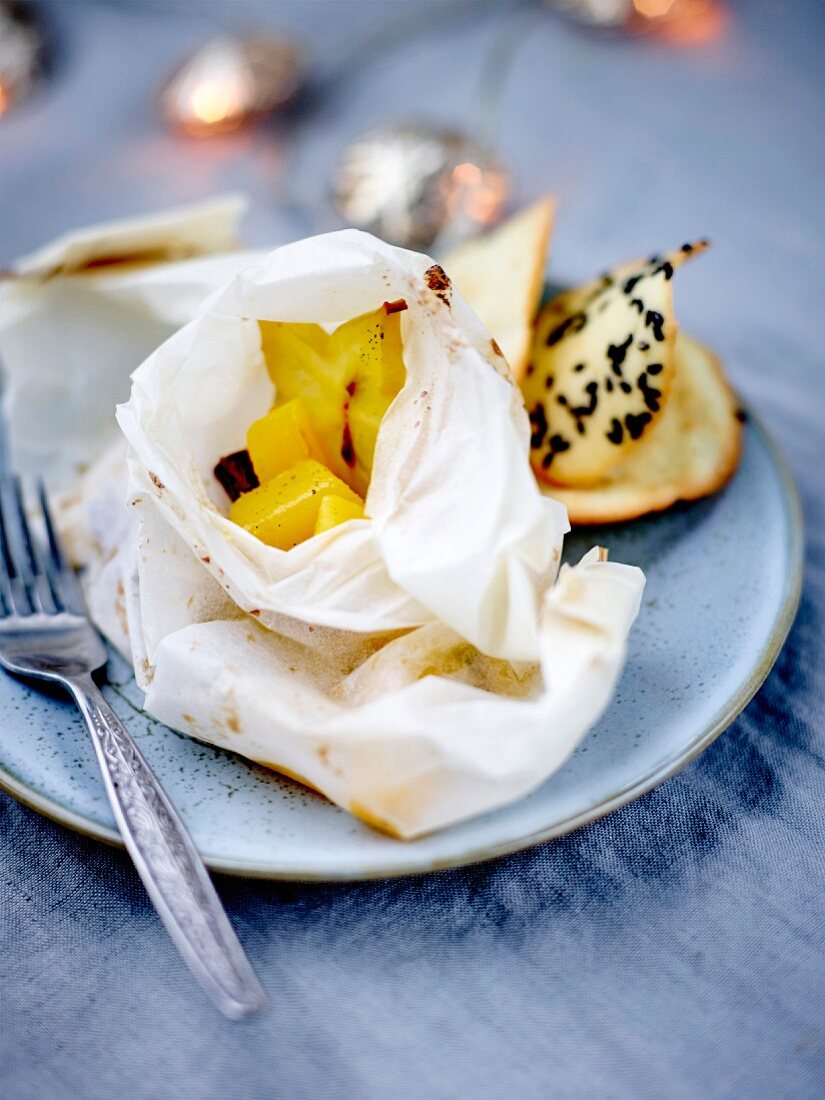 Spicy mango and star fruit papillote, black sesame seed tuiles