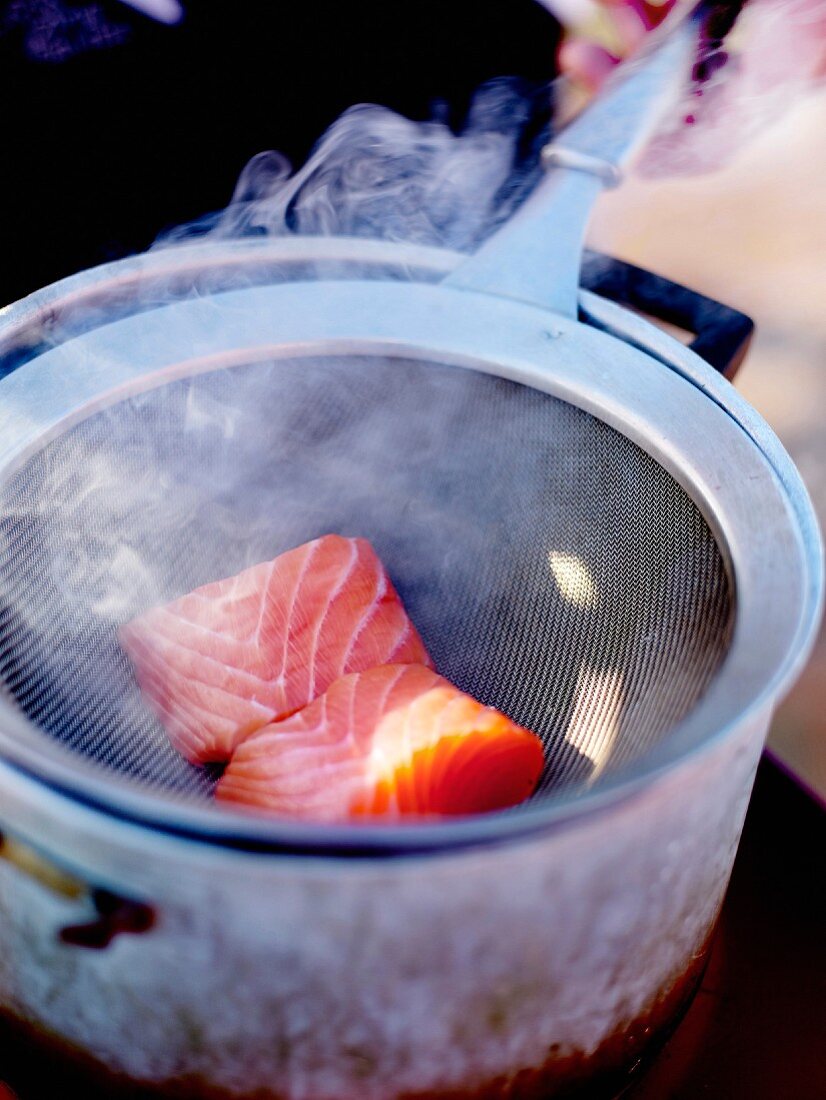 Smoking salmon at home in a casserole with hay