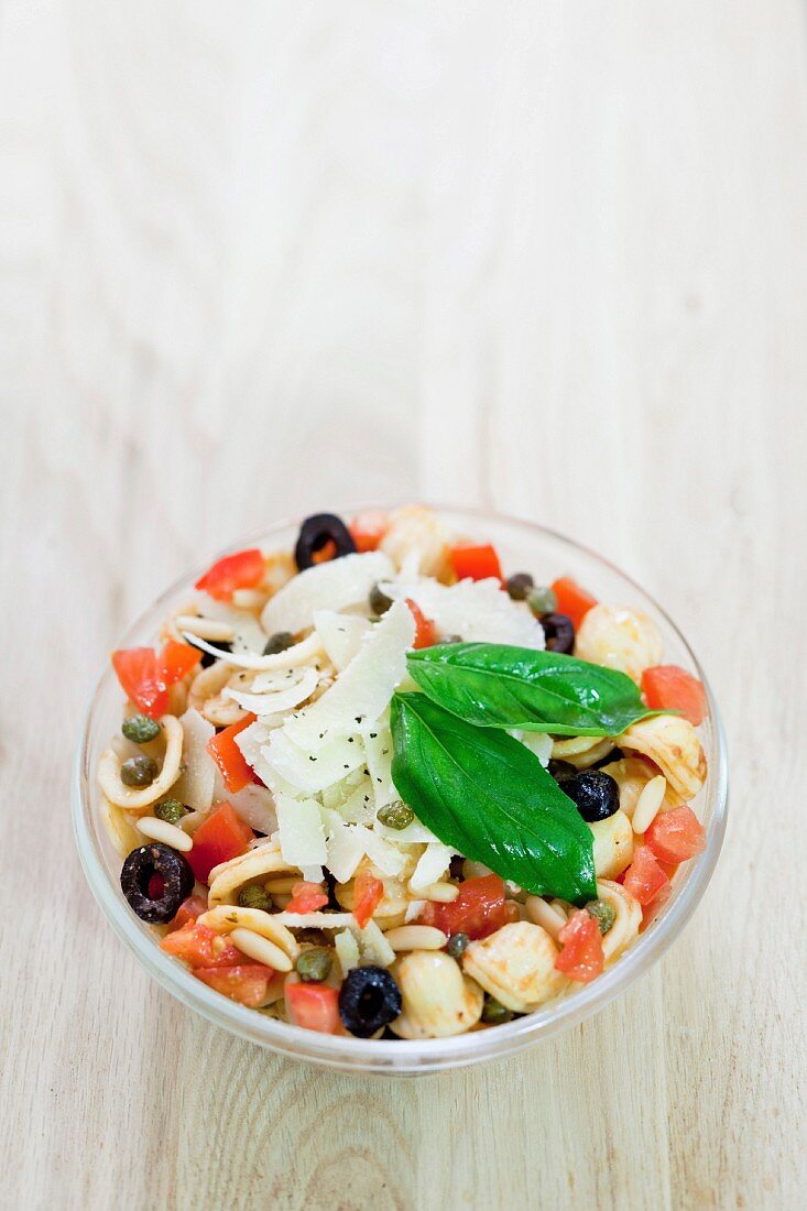 Nudelsalat mit Tomaten, Kapern, Oliven, Pinienkernen, Parmesan und Basilikum
