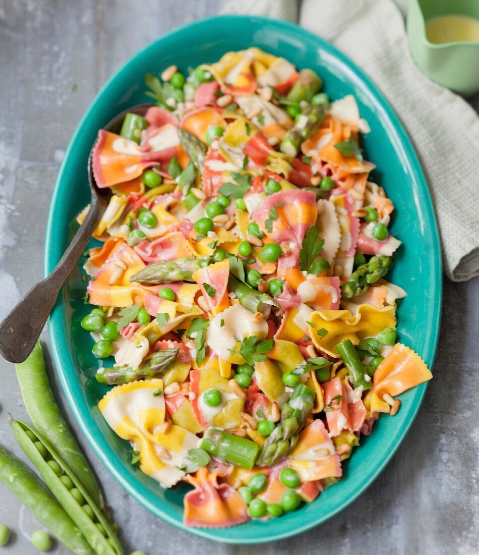 Multicolored farfalle with peas and green asparagus