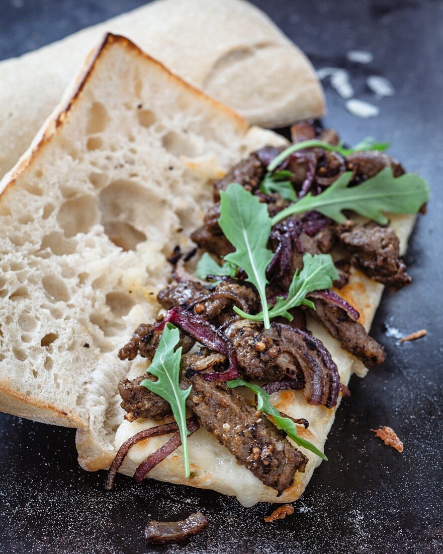 Panini mit geschnetzeltem Lendenfilet vom Rind, Provolone, Zwiebel, Rucola und Meerrettich-Mayonnaise