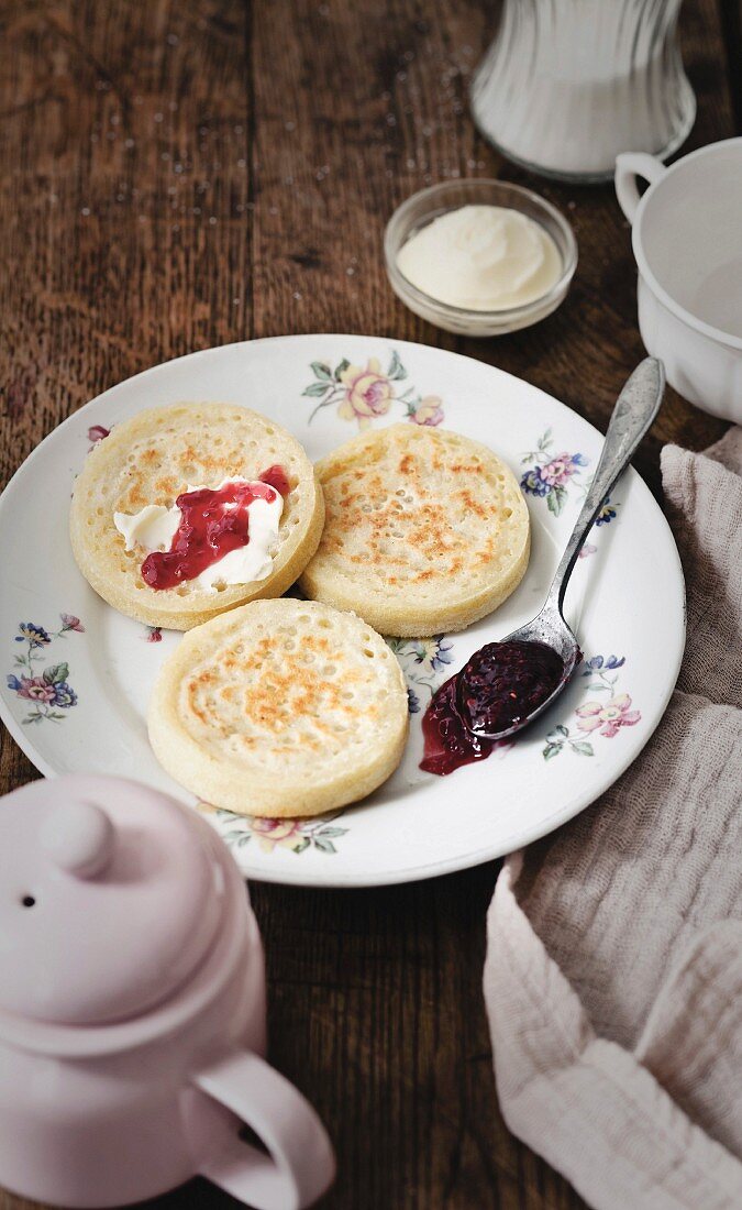 Crumpets (Hefebrötchen aus England) mit Butter und Himbeermarmelade