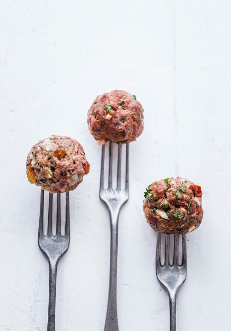 Raw meatball trio on forks