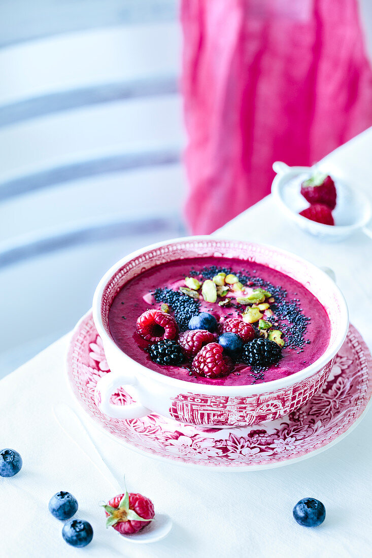 Smoothie bowl with red fruits, pistacchios and poppy seeds