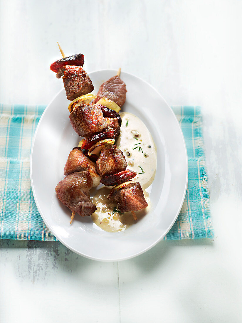 Pork, onion and chorizo skewer with Munster cheese sauce