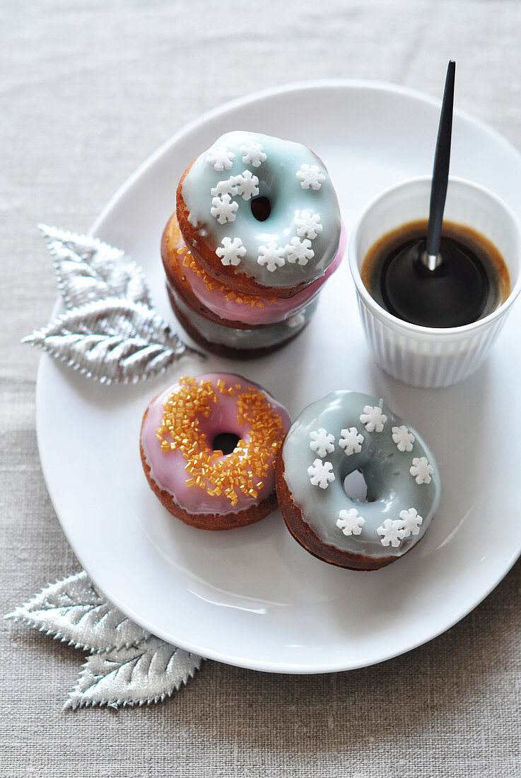 Donuts decorated with icing and a cup of coffee
