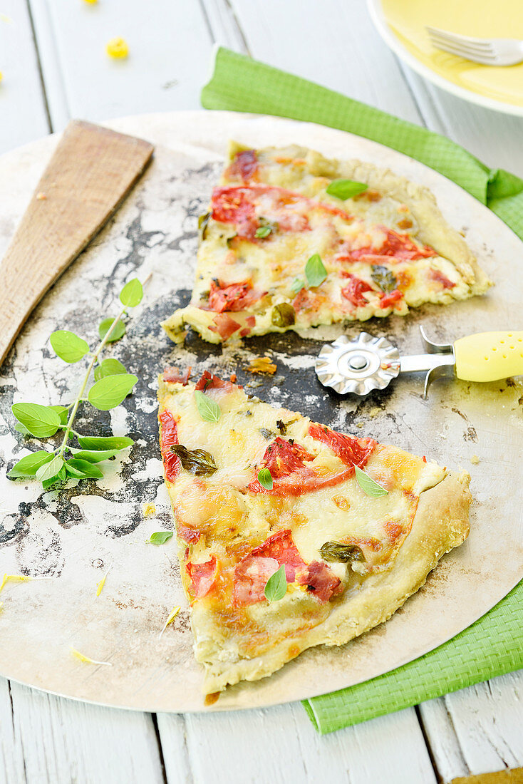 Zwei Stücke Pizza mit Matchatee, Tomaten, Basilikum und Käse