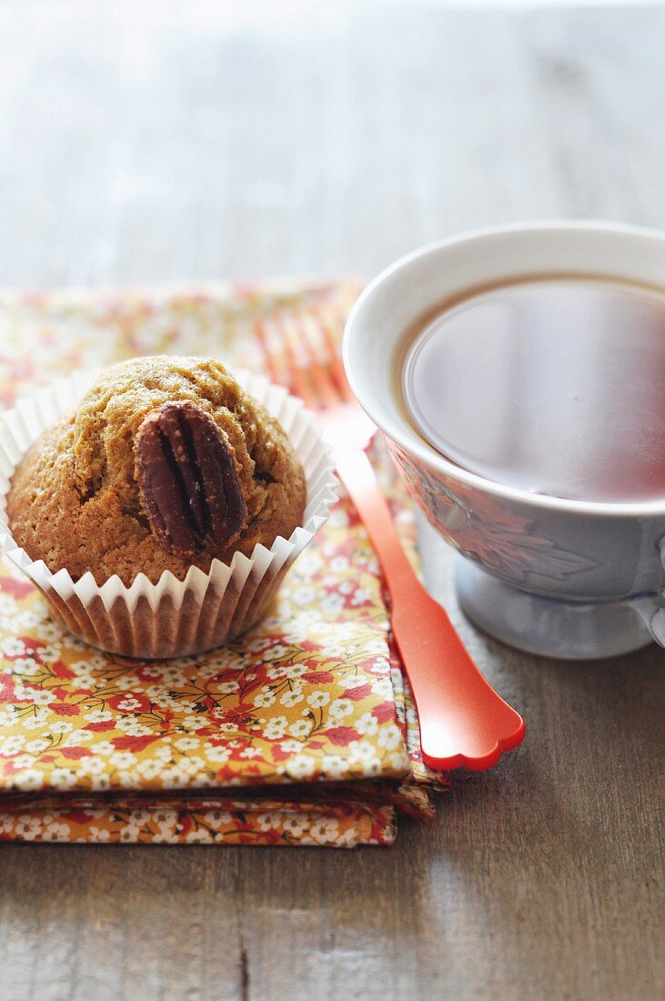 Kürbis-Muffin mit Pekannüssen und Tasse Schwarztee