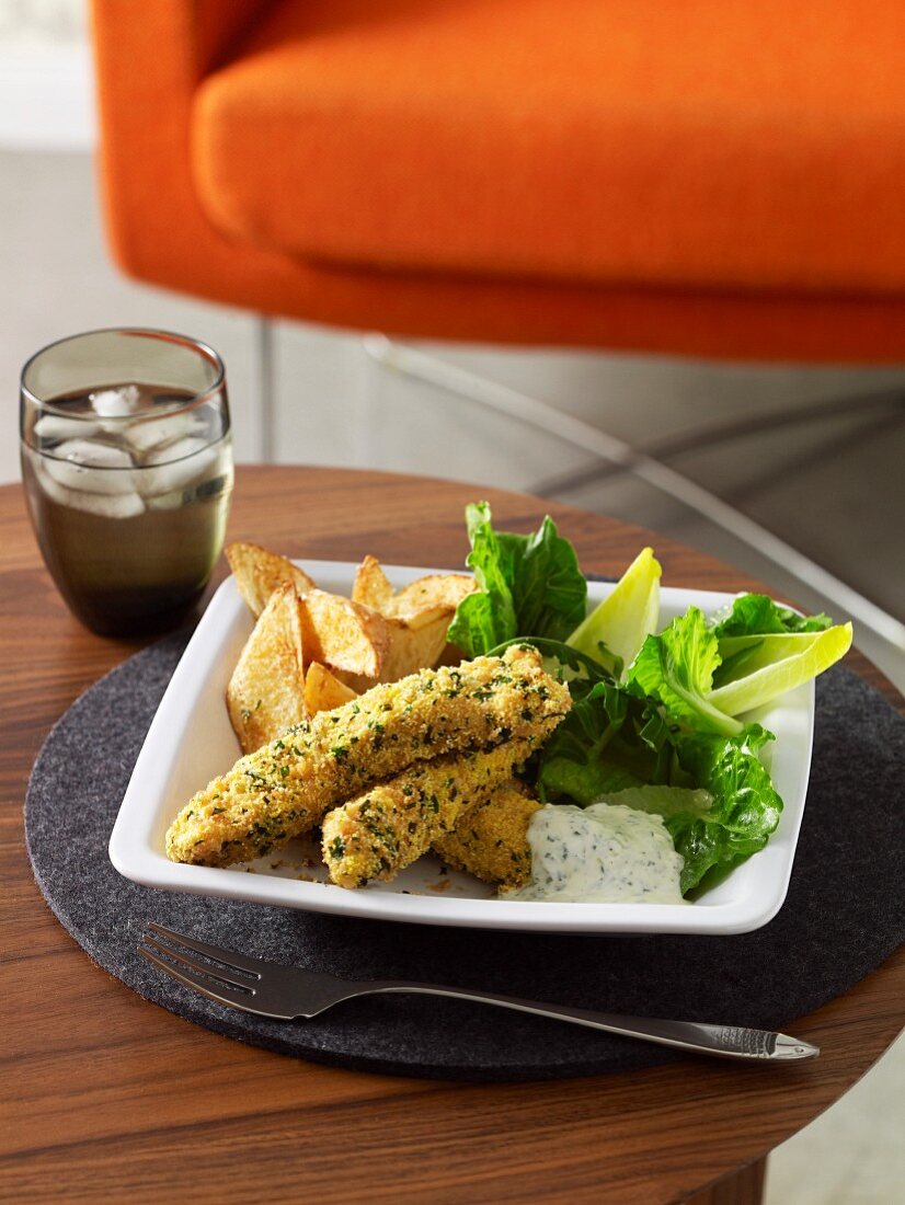 Baked fish fingers with herb crust, aioli and potato wedges