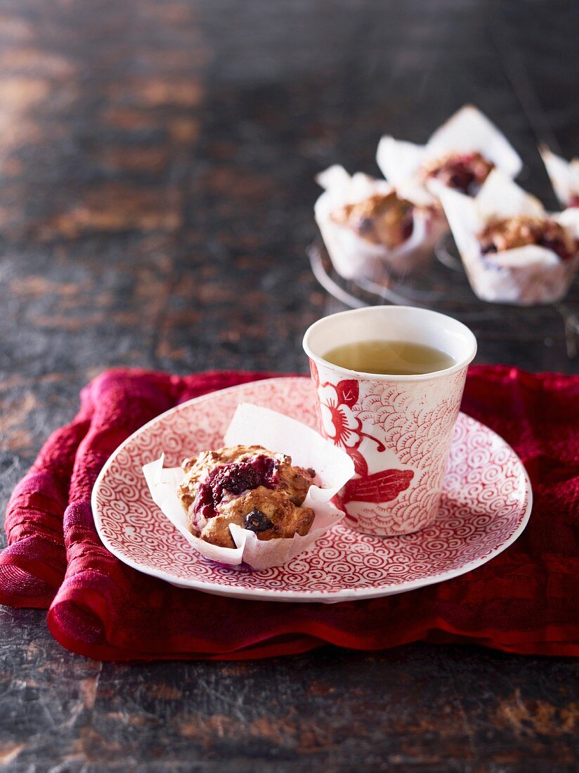 Muffin mit Waldfrüchten und Becher Schwarztee