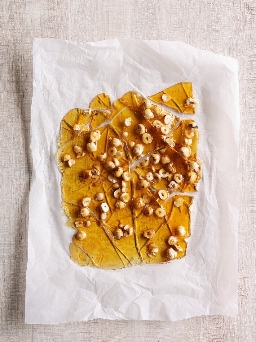 Broken slab of hazelnut caramel on ax paper