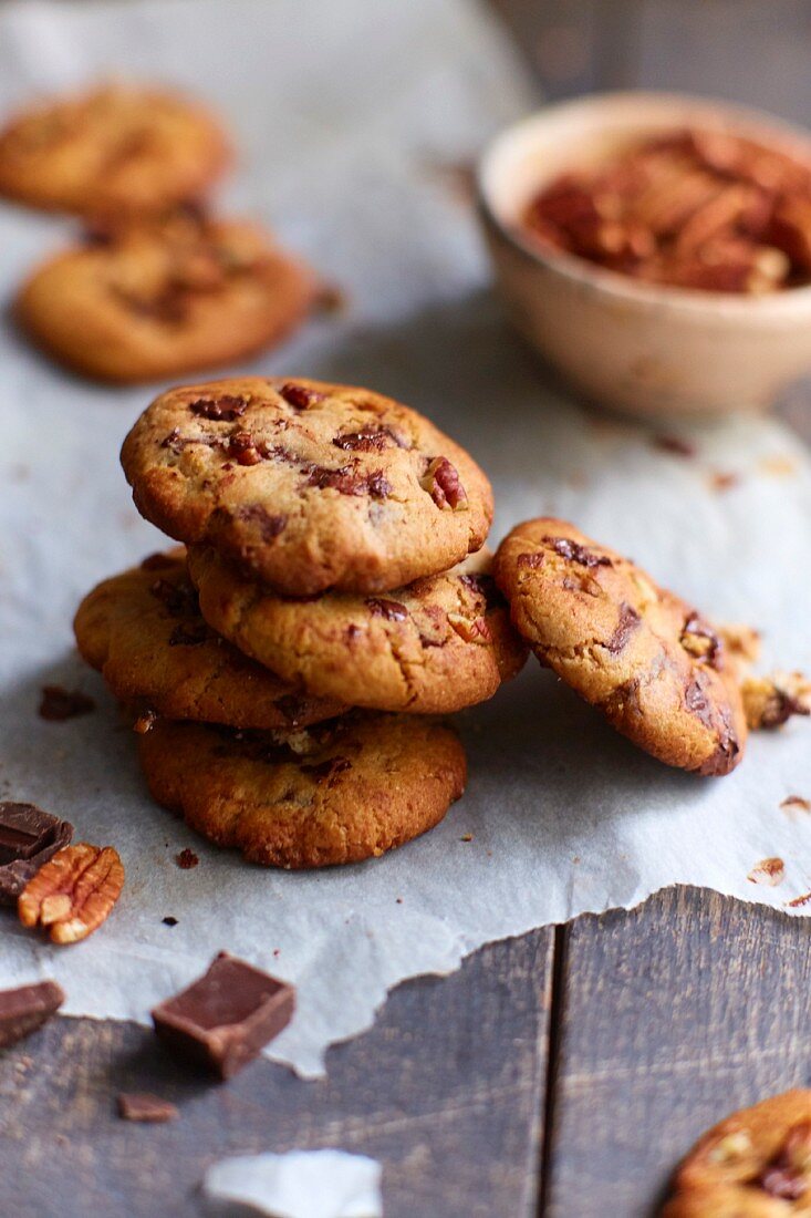 Gestapelte Cookies mit Pekannuss und Schokoladenstückchen, auf Backpapier