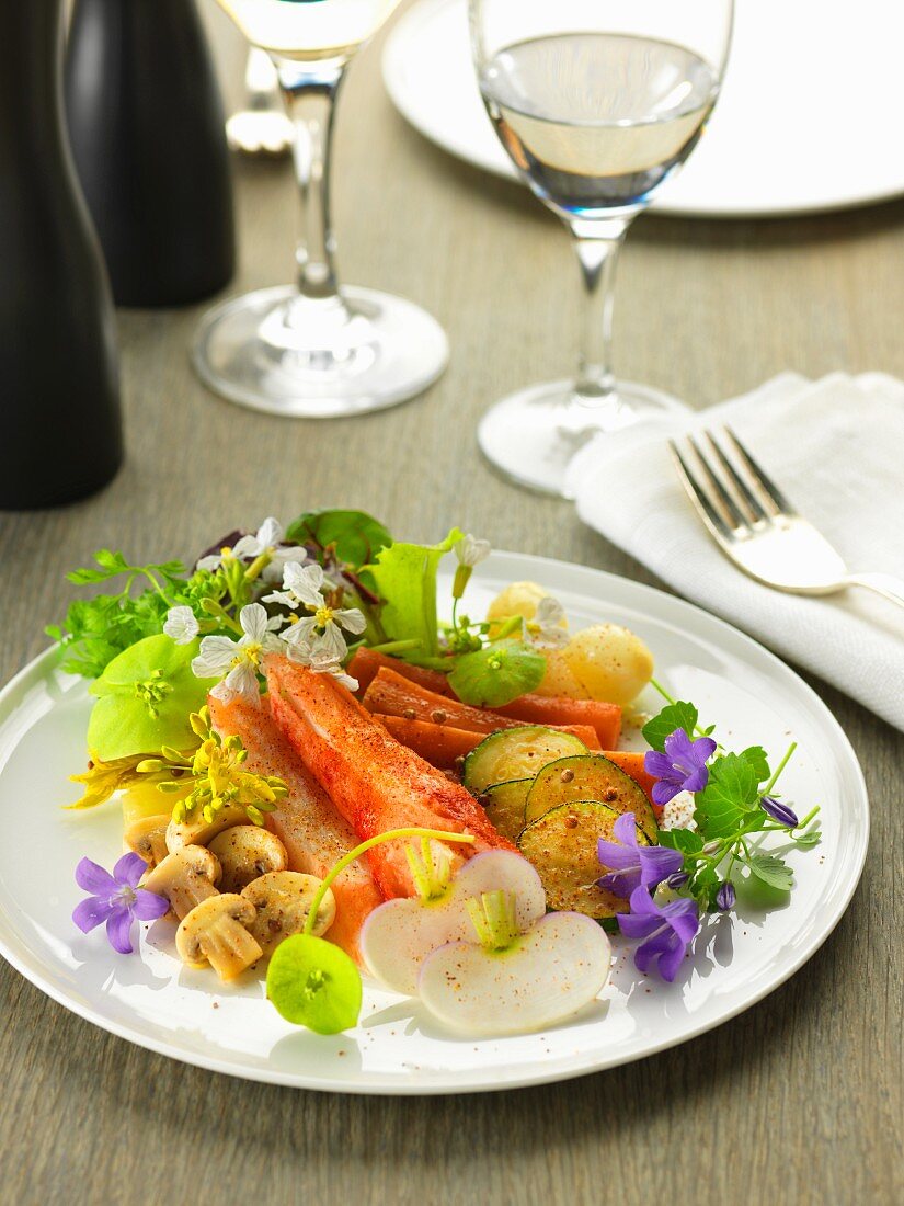 Dish of royal crab, vegetables, edible flowers and spices