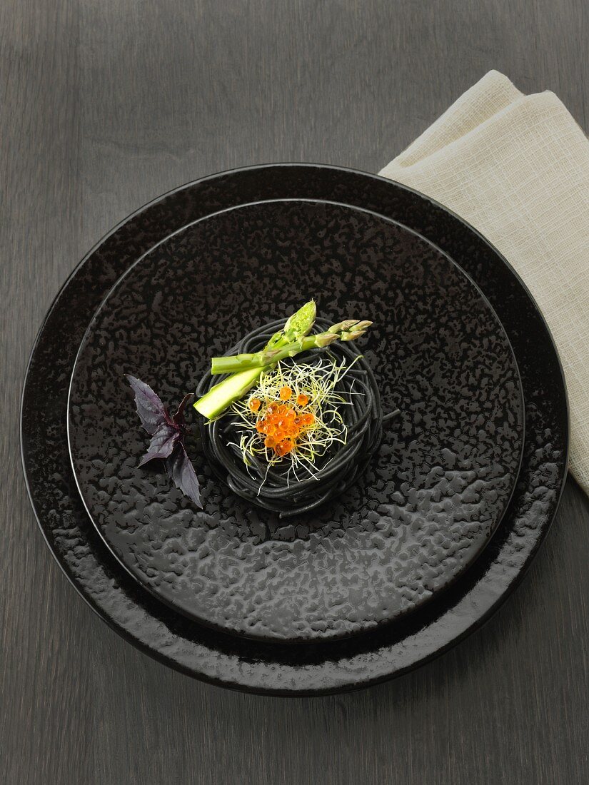 Squid ink spaghettis, green asparagus tops, sprouts and salmon roe