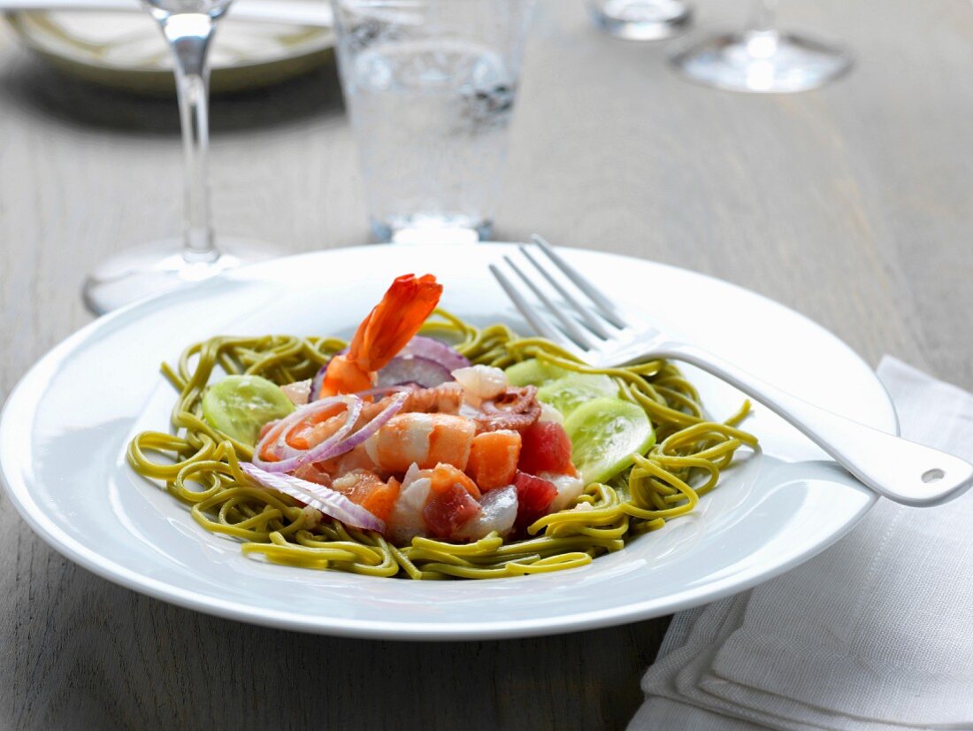 Salat mit Spinatspaghetti, Garnelen, Fischtatar, roten Zwiebeln und Gurke