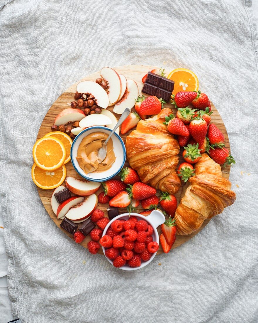 Frühstückstablett mit Croissants und Früchten