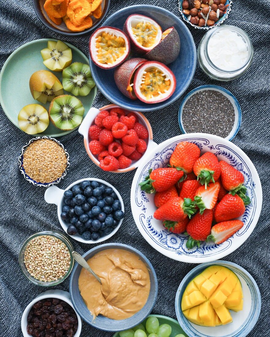Verschiedene Zutaten für Fruit Bowl: frische Früchte, Trockenfrüchte, Cerealien und Sesampaste