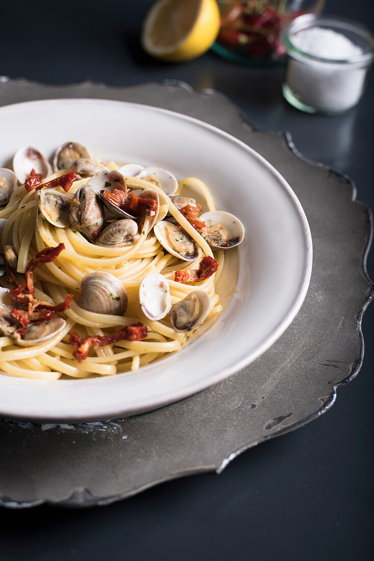 Linguine with clams and sun-dried tomatoes on a black background
