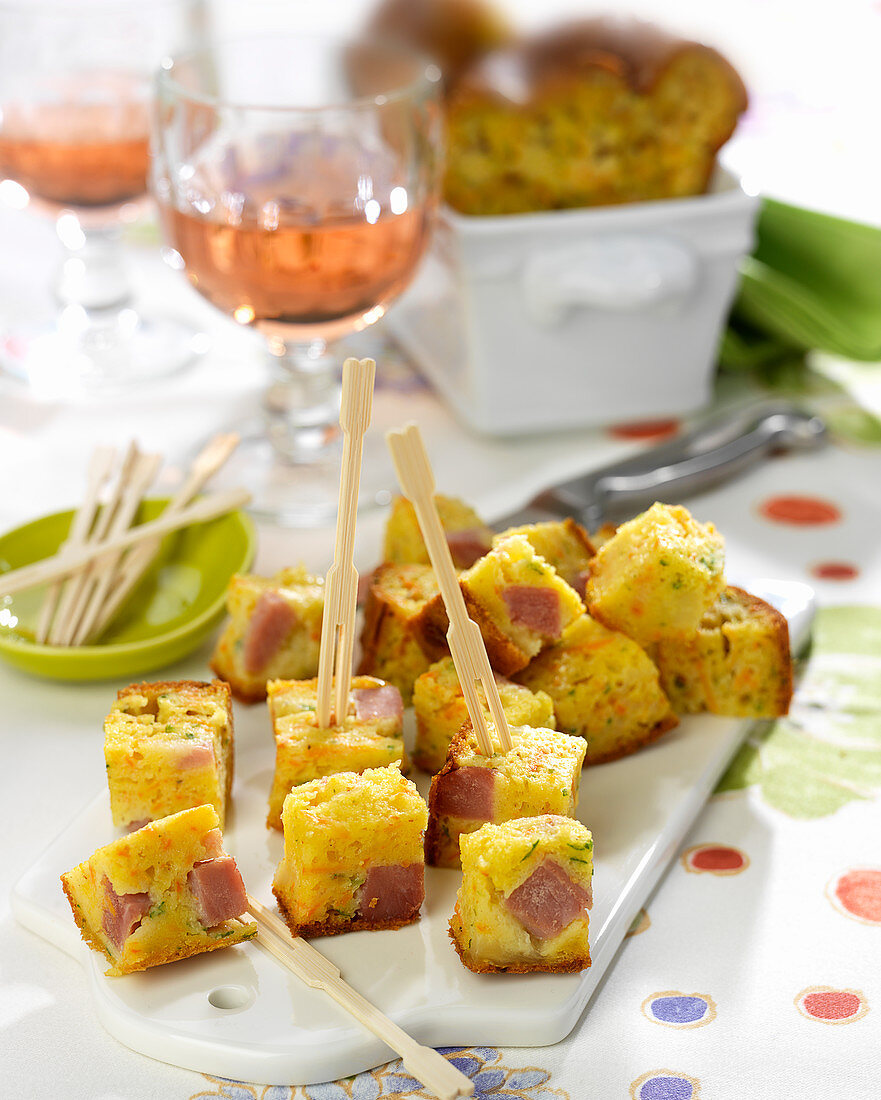 Herzhafter Kastenkuchen mit Karotten, Comté-Käse und Schinken, in Würfel geschnitten