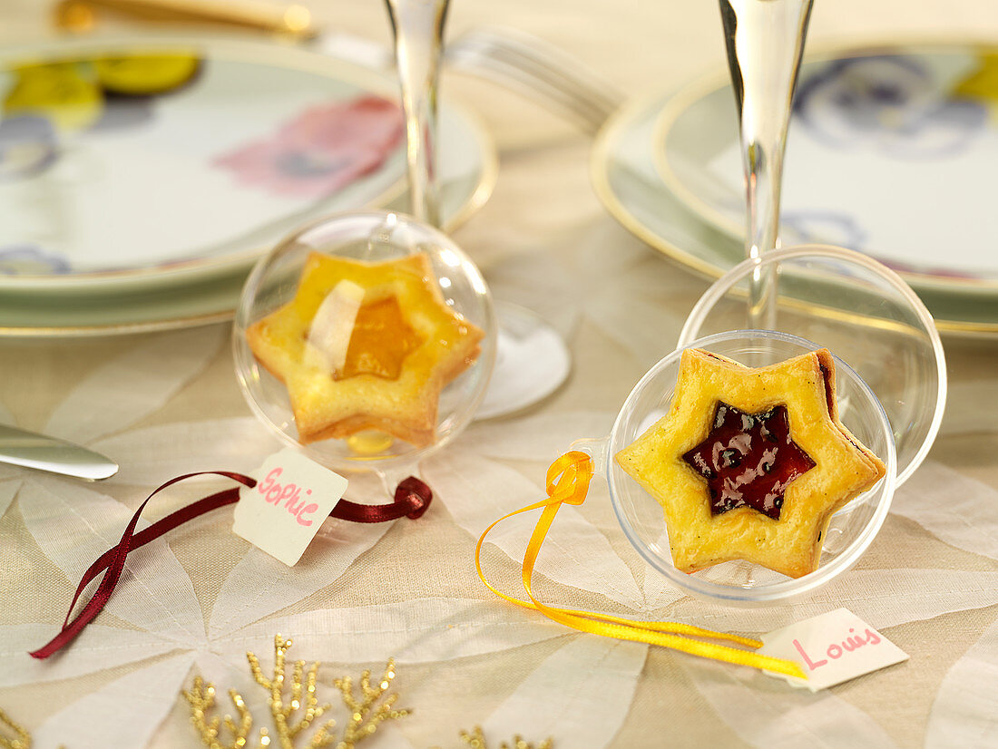 Tischkärtchen mit durchsichtiger Christbaumkugel und Mürbteigsterne, mit Aprikosenmarmelade und mit Waldfruchtmarmelade