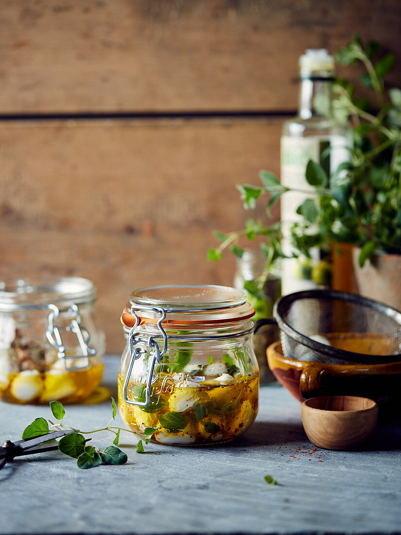 Jars of marinated mozzarella balls with oil and herbs