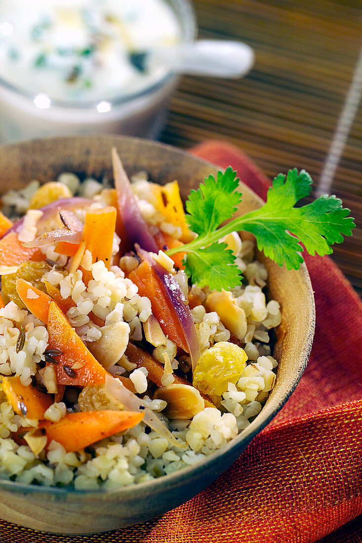 Bulgur mit Gewürzen, gebratenem Gemüse, Rosinen und Mandeln