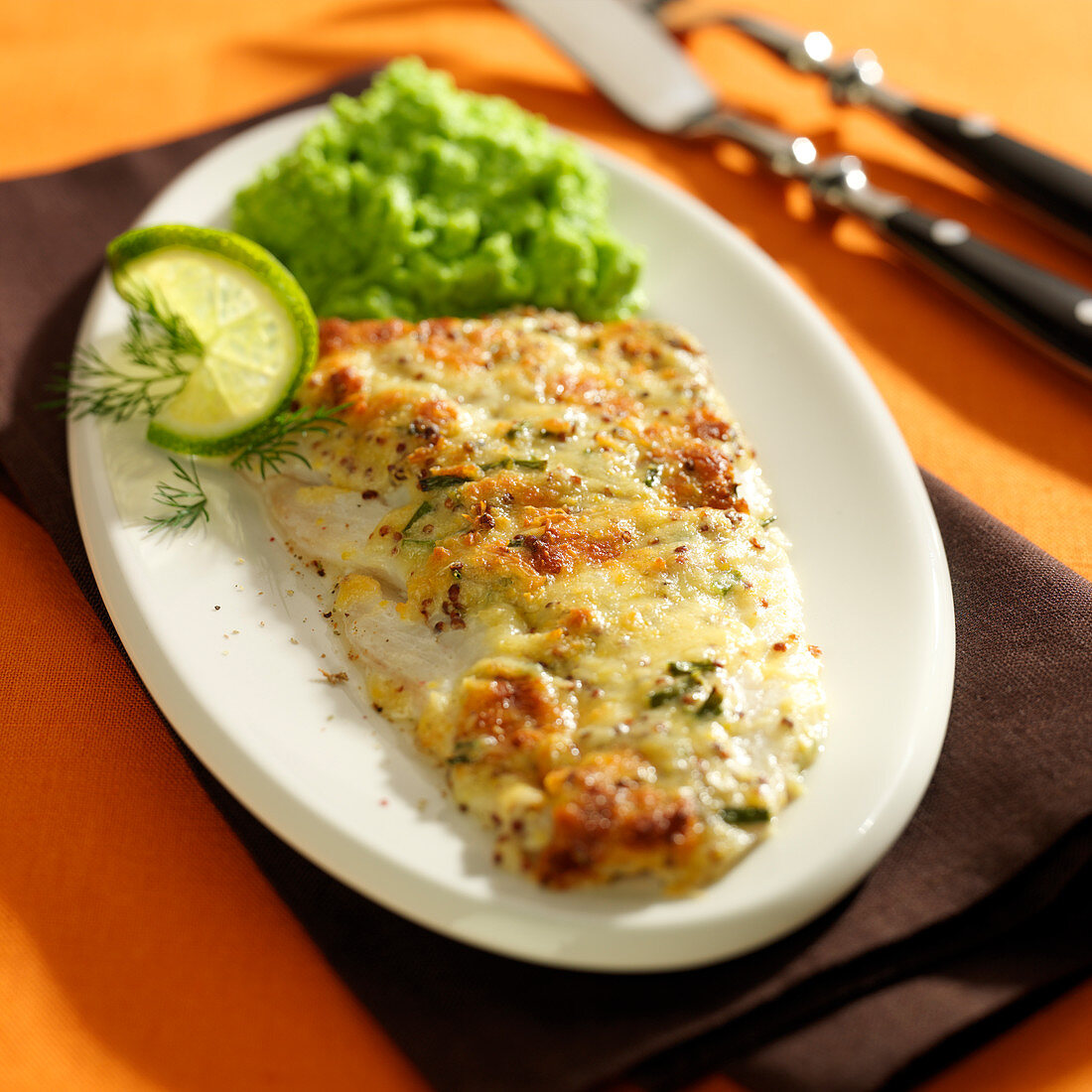 Cod fillet coated and grilled with cheese and mustard sauce, mashed peas