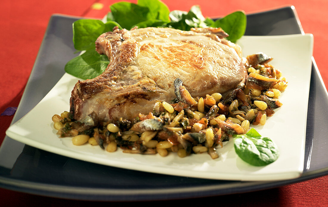 Pork chop with anchovies, pine nuts, mushrooms and baby spinach