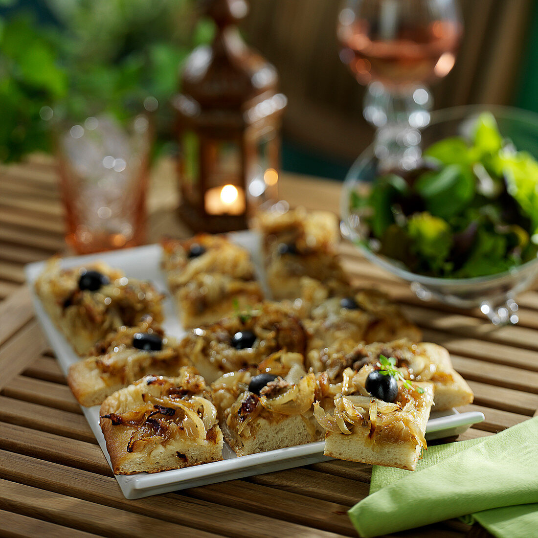 Pissaladière (Zwiebelkuchen mit Sardellen und Oliven) in Stücke geschnitten, zum Aperitif
