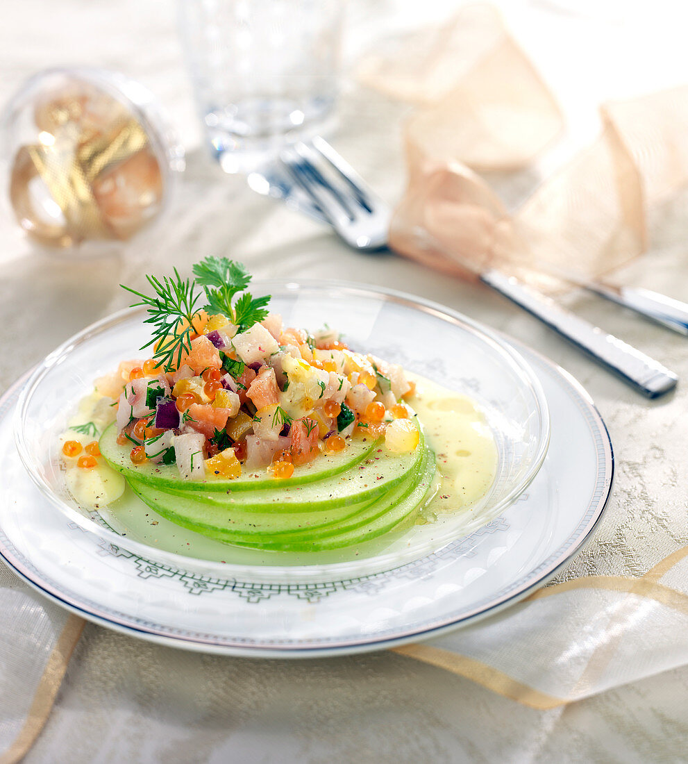 Thin round slices of Granny Smith apples topped with haddock, salmon and herring tartare