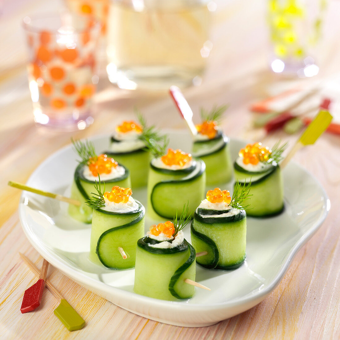 Cucumber rolls garnished with cream cheese and salmon roe