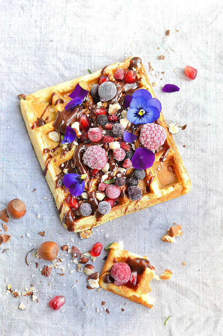 Waffle with fresh fruit, dried fruit, flowers and chocolate sauce