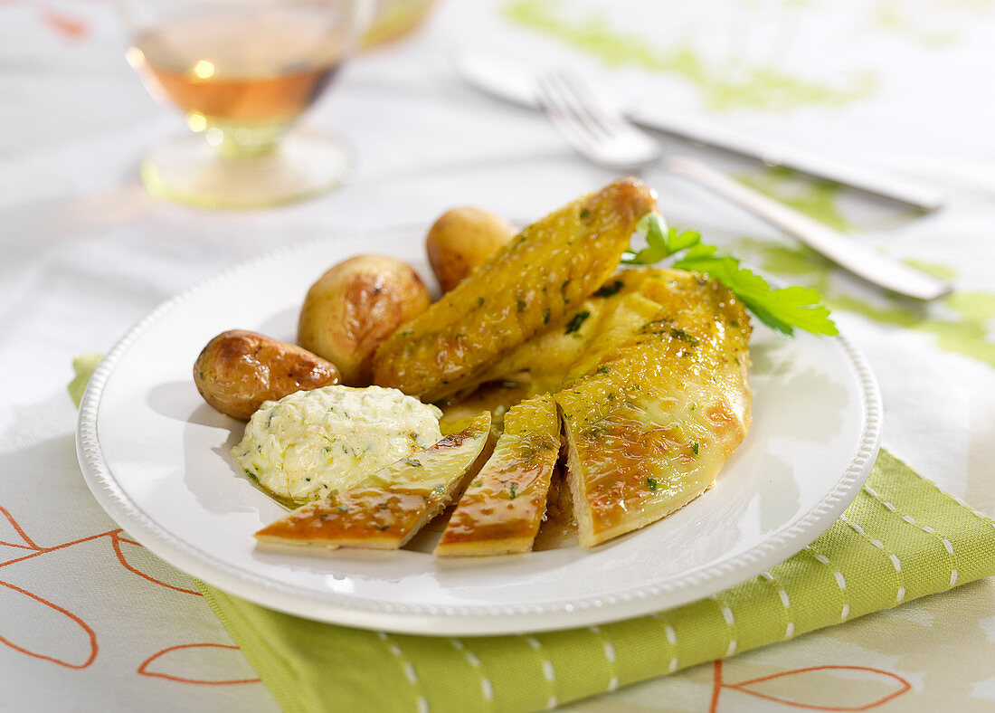 Huhn gefüllt mit Kräuterfrischkäse serviert mit gebratenen Pellkkartoffeln