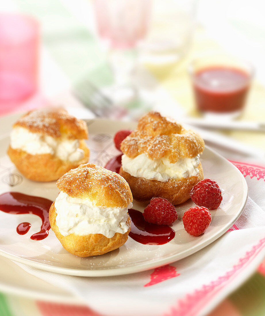 Whipped cream puffs with raspberry coulis