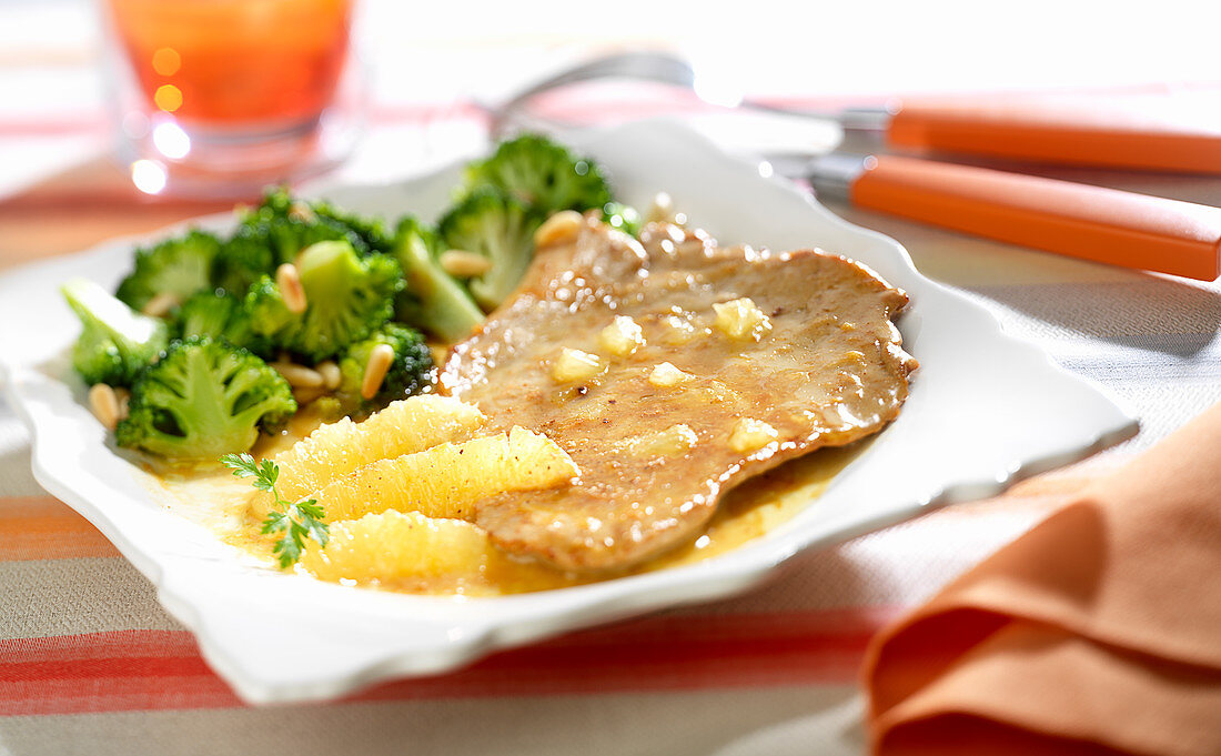 Veal escalope with lemon, broccolis and grilled pine nuts