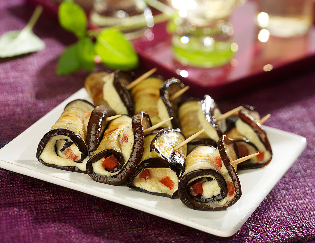 Aubergine rolls garnished with chickpea puree and diced tomatoes