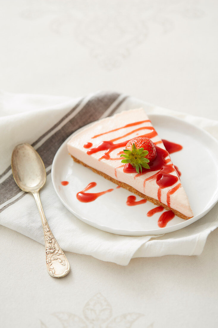 Ein Stück Cheesecake mit Erdbeercoulis