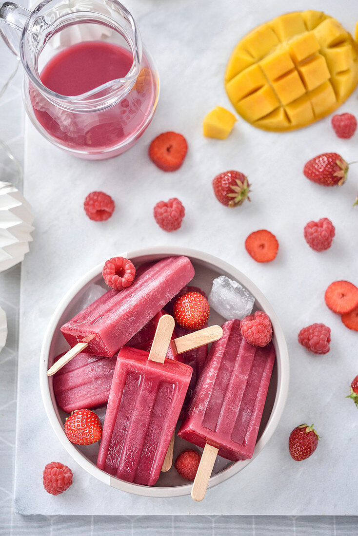 Mango-strawberry and raspberry smoothie ice pops