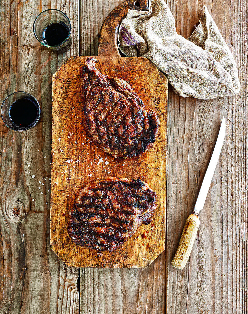 Grilled rump steaks on a wooden chopping board