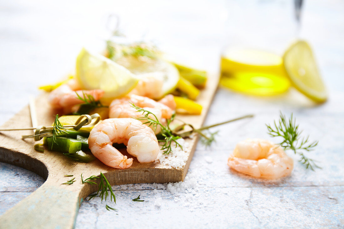 Shrimp,peppers,lemon,dill and Fleur de sel sea salt on a chopping board