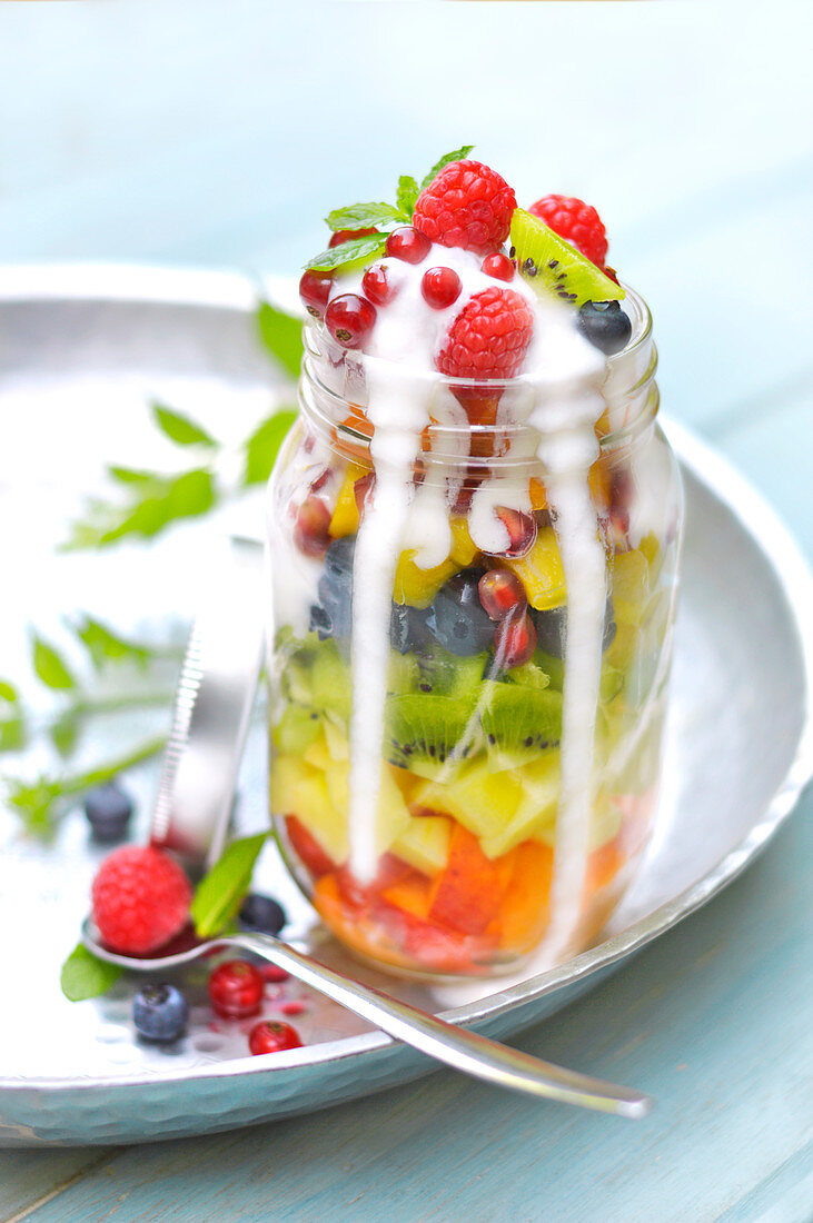 Fresh fruit salad in a jar with runny yoghurt