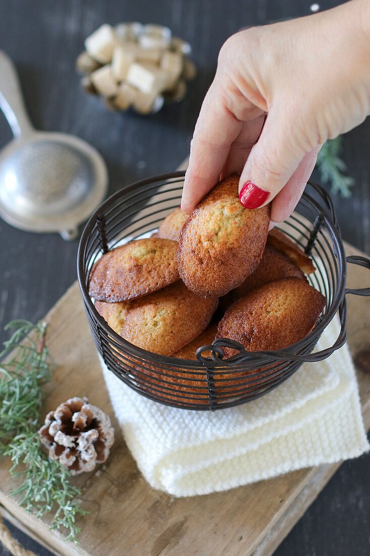 Woman's hand taking a madeleine with buckwheat and honey