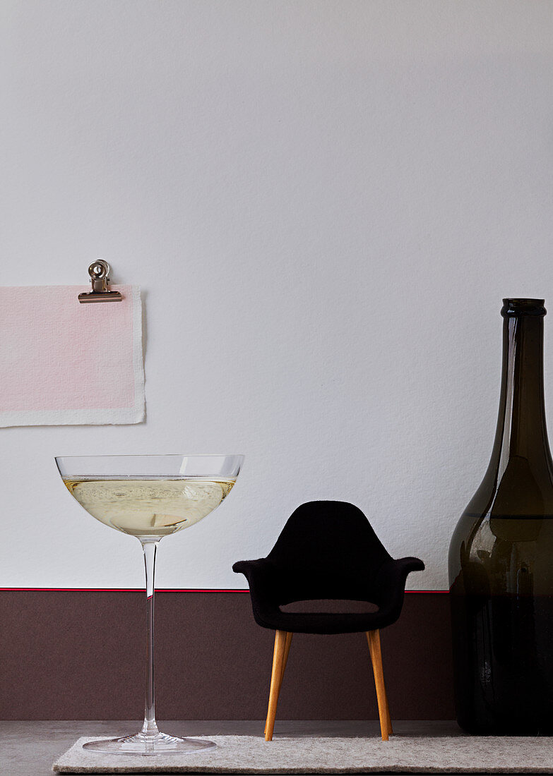Giant glass and bottle of Champagne with a miniature designer's armchair