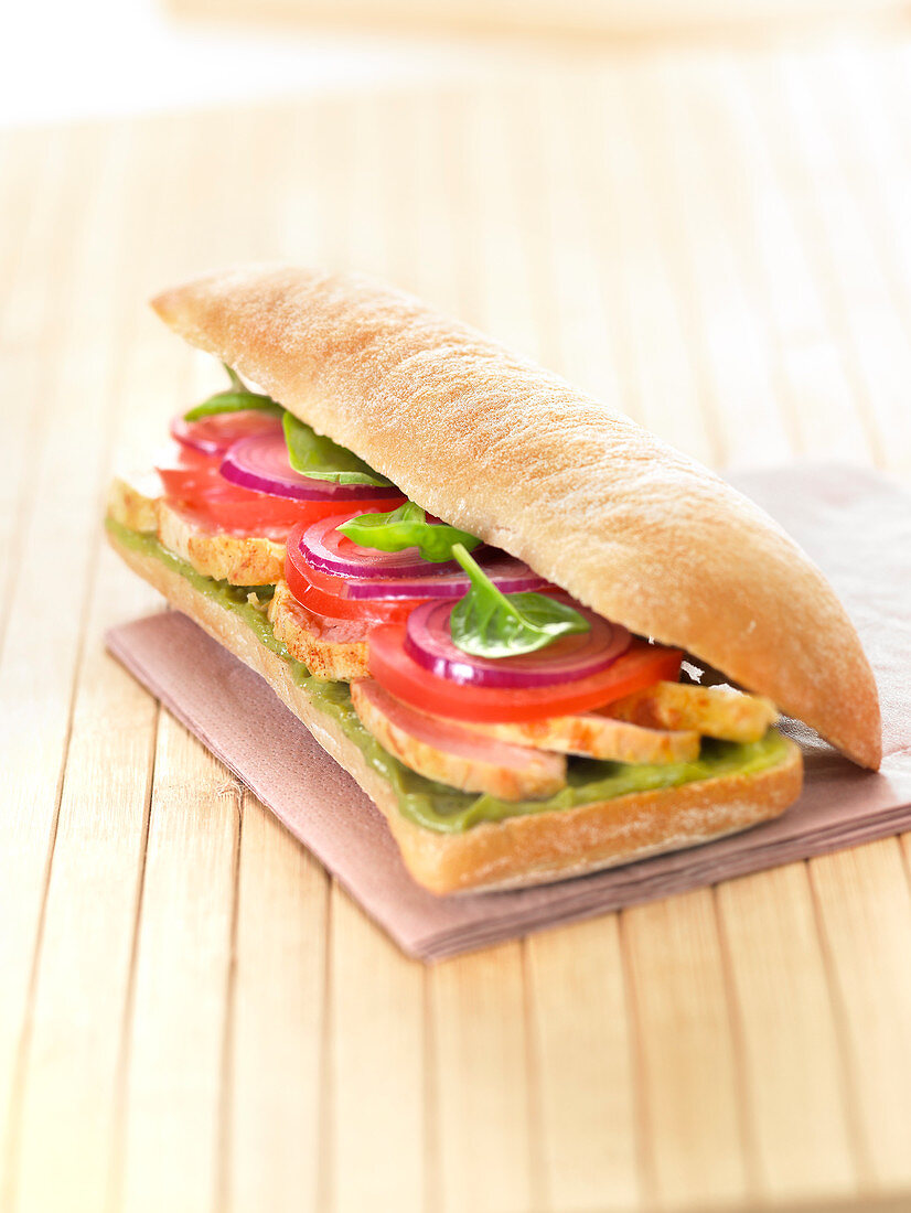 Ciabatta-Sandwich mit Hähnchen, Tomaten, roten Zwiebeln, Babyspinat und Guacamole