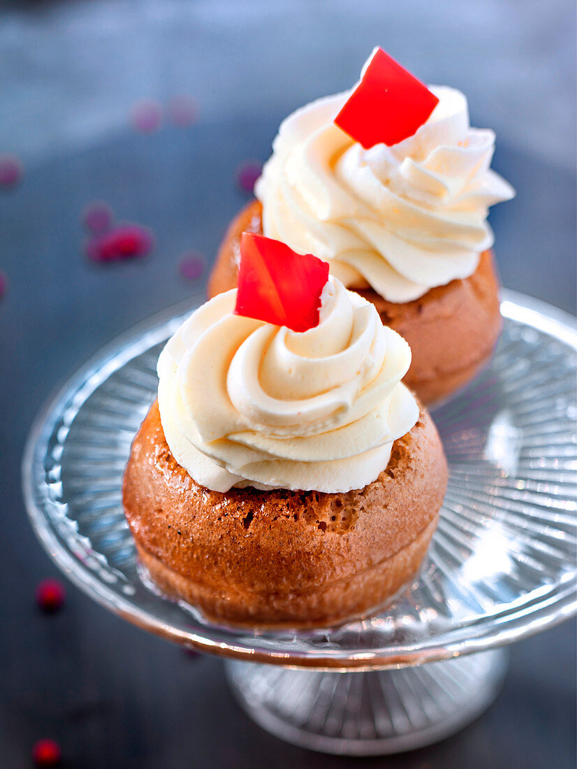 Zwei kleine Baba au rhum (in Rum getränkter Napfkuchen, Frankreich) mit Schlagsahne